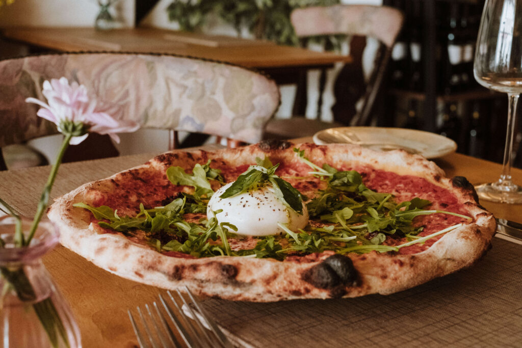 Wood-fired pizza topped with rocket and torn burrata