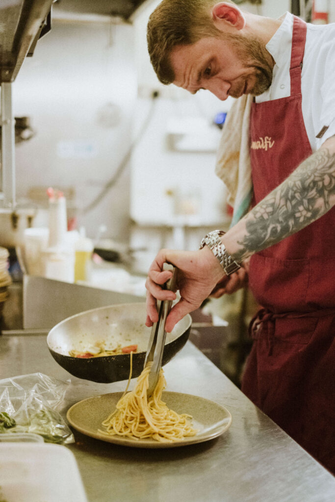 Chef plating fresh pasta in the Amalfi kitchen